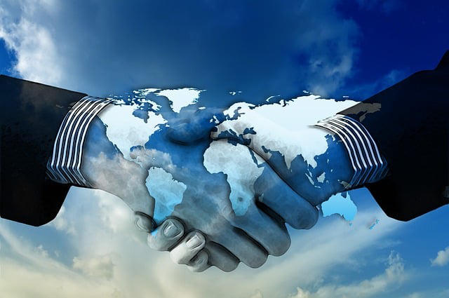 shaking hands over a sky background with continents overlayed representing how UX affect SEO