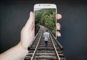 Artistic concept with a railroad track leading into a mobile phone.